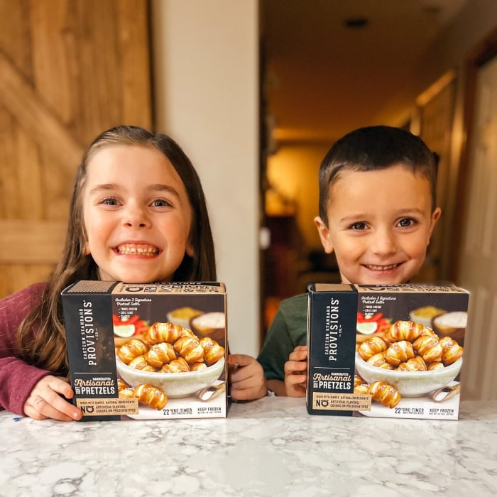 Girl and boy, each holding box of pretzels